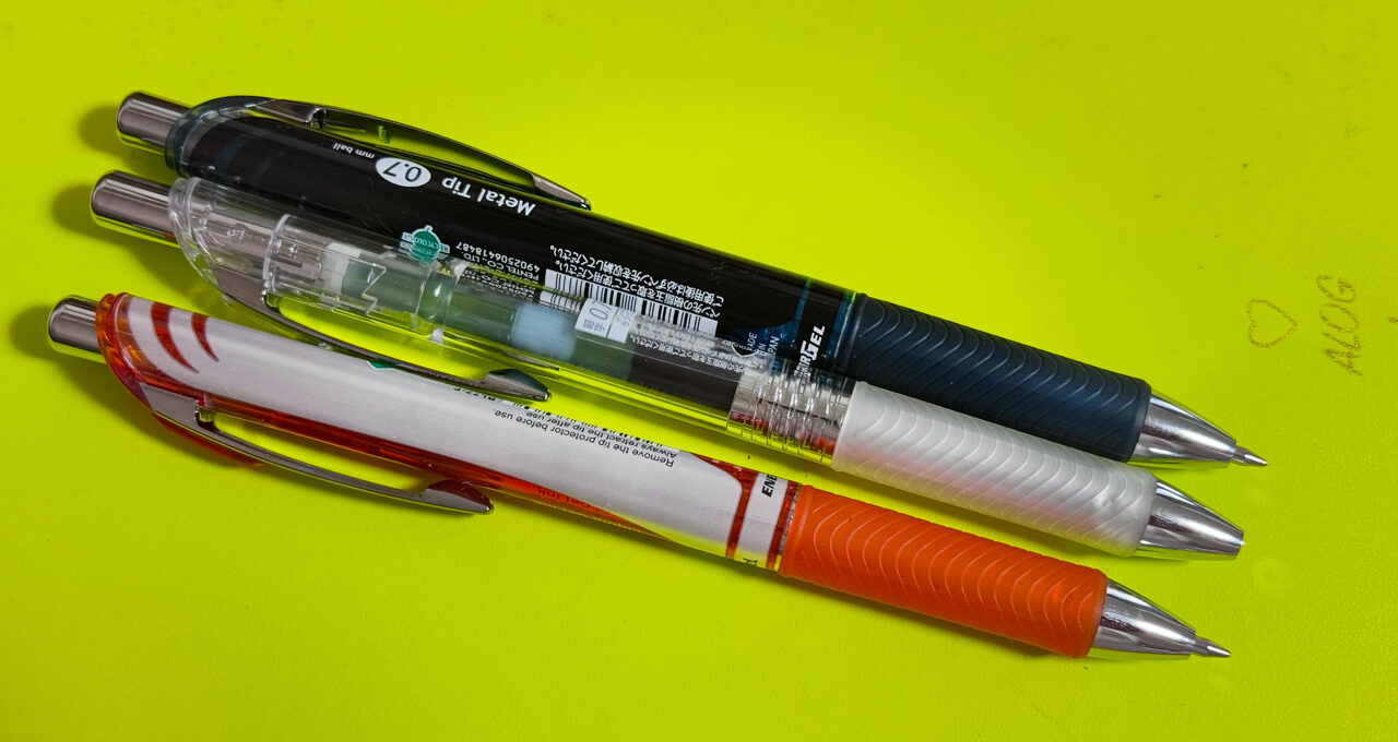 モレスキンの上に並べたエナージェル 0.7mm インディゴブラック & オレンジ & ラフグレー