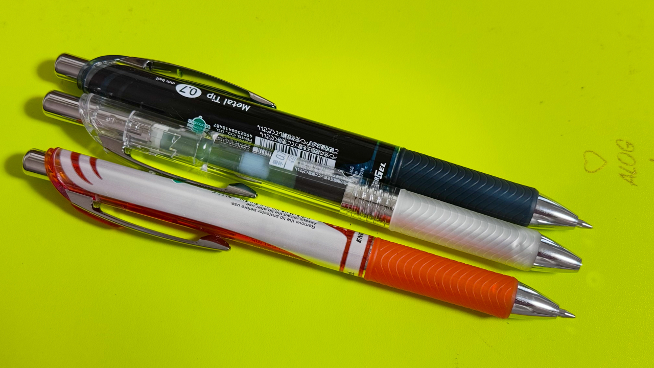 モレスキンの上に並べたエナージェル 0.7mm インディゴブラック & オレンジ & ラフグレー