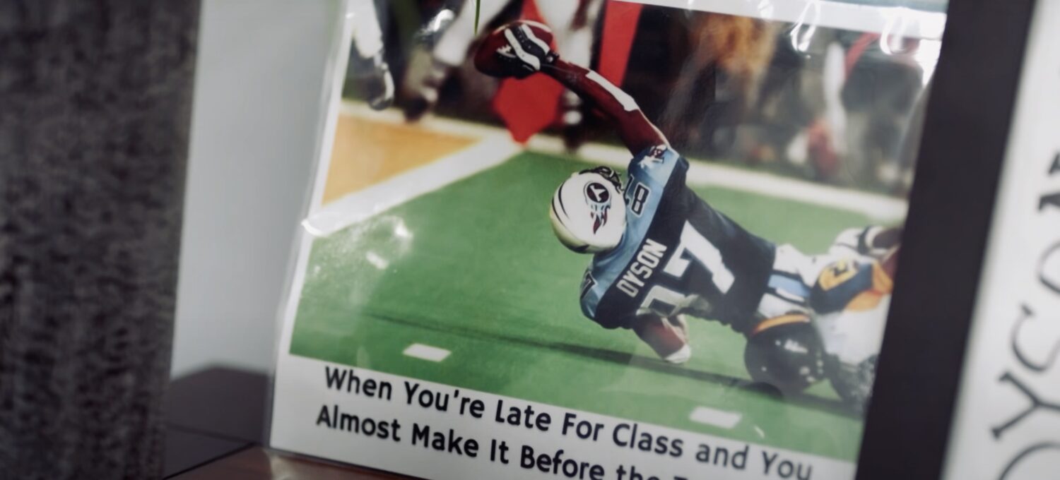 アメリカンフットボール選手がキャッチを試みている写真。彼は芝生の上で倒れながらボールを掴もうとしている。下部には「授業に遅れそうで、ほぼ間に合いそうな時」と書かれている。